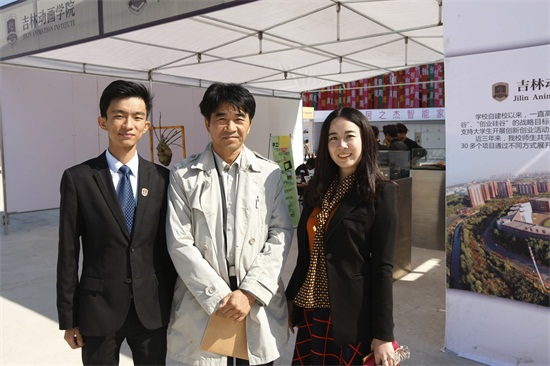 学校副校长、文化产业管理学院院长蒙一丁(中)与参展学生合影.JPG